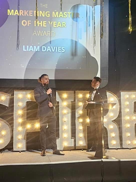 Liam Davies on stage receiving the Marketing Master of the Year award